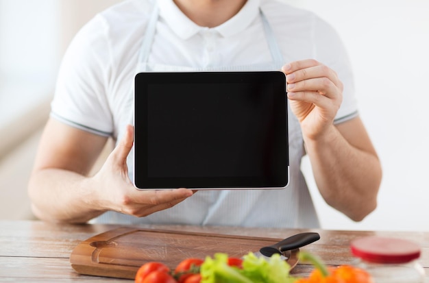 cooking, technology, advertising and home concept - close up of male hands holding tablet pc with blank black screen