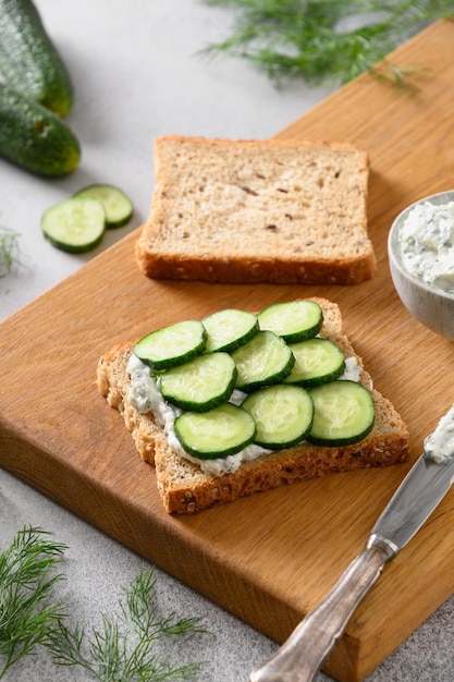 Cooking traditional English tea cucumber sandwiches with ricotta and dill for breakfast