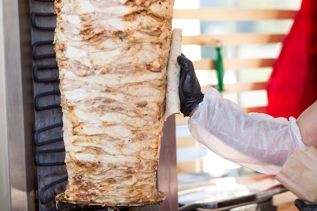 Фото Готовим турецкий донер кебаб. шеф-повар смазывает лаваш жиром из мяса.