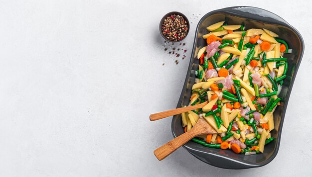 Cooking vegetable stew with meat raw vegetables and turkey meat\
in a baking dish