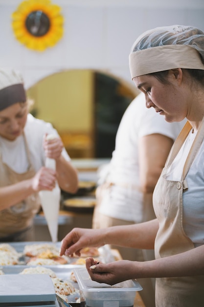 Cooks cook pizza in the bakery closeup