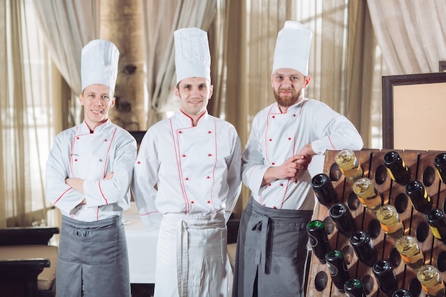 cooks in a restaurant with wine bottles