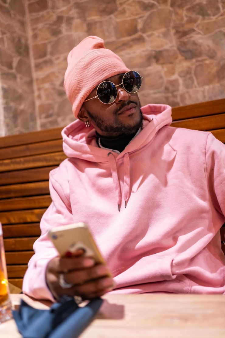 Photo cool african man using phone sitting in a bar