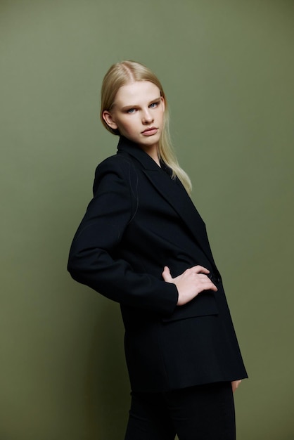 Cool banner for brands An attractive cool professional model poses in a halfturn and looks at the camera on a green olive background in the studio