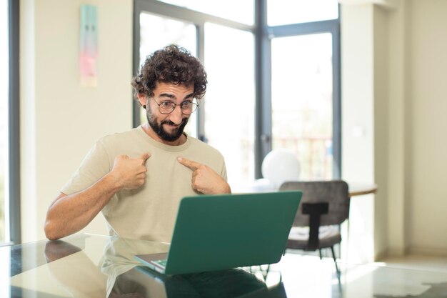 Bell'uomo barbuto che lavora a casa su un computer portatile