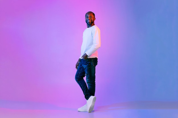 Cool black man posing on colorful background full length shot