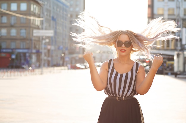 Foto cool blond meisje met wind in haar poseren met zacht zonlicht. ruimte voor tekst
