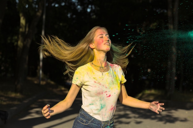 Foto una bella donna bionda che si scompiglia i capelli al festival di holi