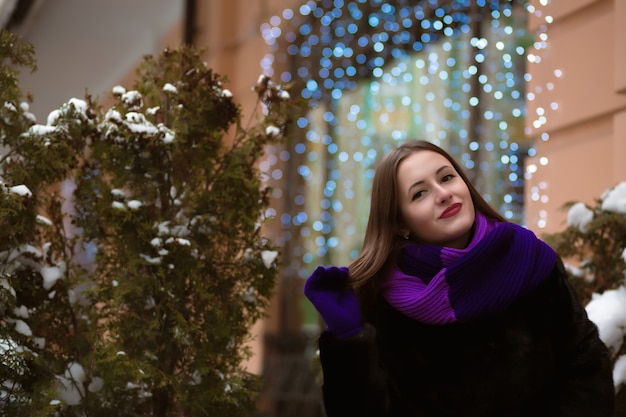 Cool brunette vrouw met lichte make-up, het dragen van bontjas, poseren op de achtergrond van bokeh