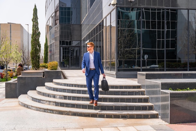 Photo cool businessman leaving the office in a sunny day