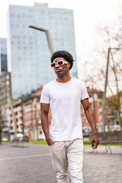 Photo cool and casual stylish african man walking along a city