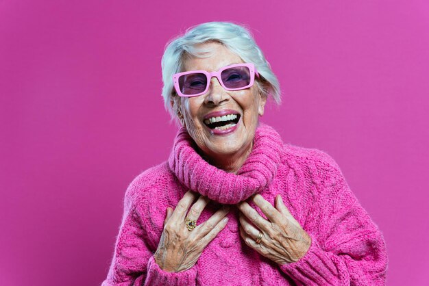 Cool grandmother posing in studio wearing fashionable clothes Happy senior lady celebrating