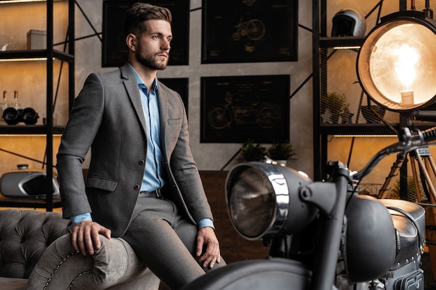 Cool and handsome. Good looking young man in full suit sitting on the sofa while spending time indoors.