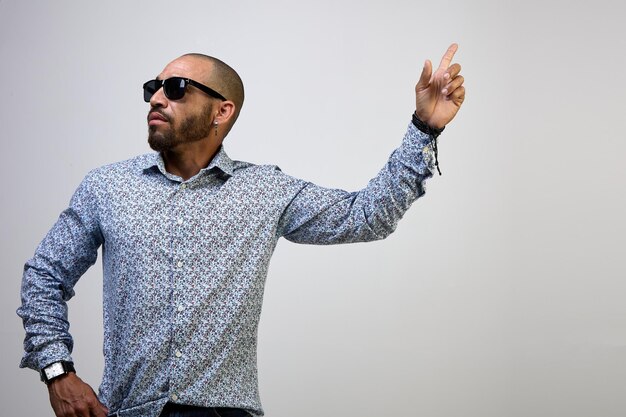 Cool latino man in a shirt pointing his finger up isolated on a white background