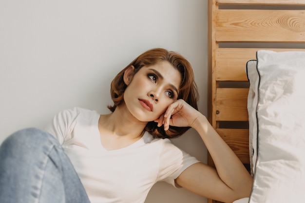 Cool looks woman in white t-shirt and jean relax in her apartment room.