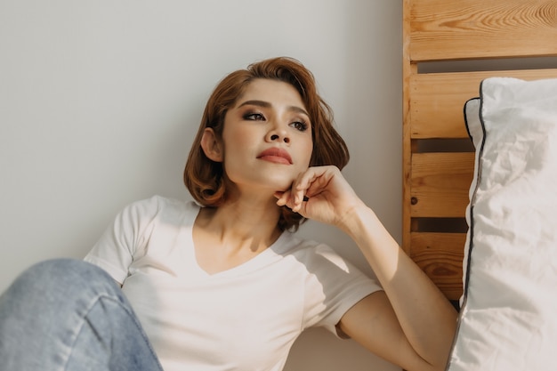 Cool looks woman in white tshirt and jean relax in her apartment room