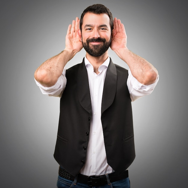 Cool man listening something on grey background