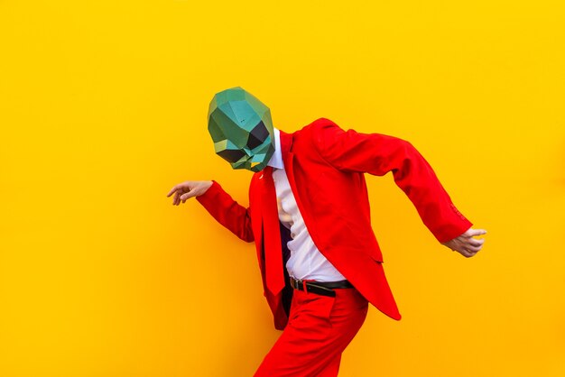 Foto cool man met 3d origami masker met stijlvolle gekleurde kleding - creatief concept voor reclame, dierenkop masker grappige dingen doen op kleurrijke achtergrond