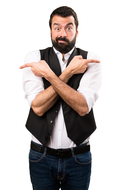 Cool man pointing to the laterals having doubts on isolated white background