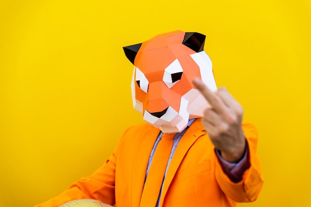 Cool man wearing 3d origami mask with stylish colored clothes - Creative concept for advertising, animal head mask doing funny things on colorful background