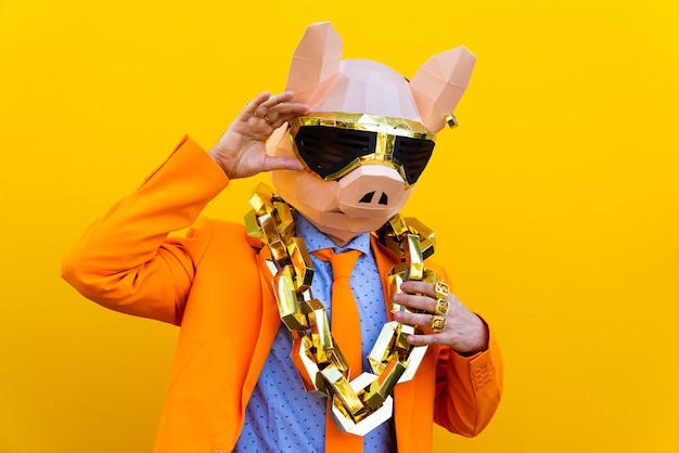 Cool man wearing 3d origami mask with stylish colored clothes  Creative concept for advertising animal head mask doing funny things on colorful background