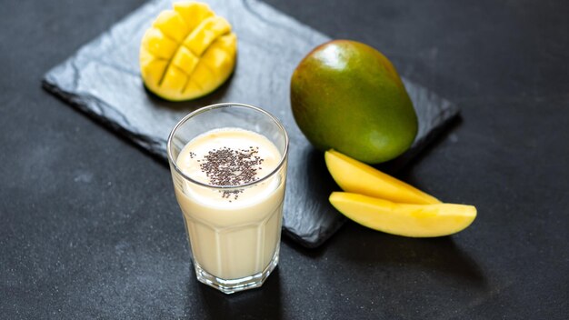 Cool mango milkshake on a black background a drink to quench your thirst in the summer indian cuisin