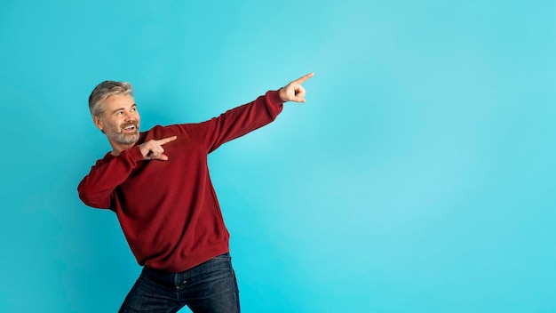 Cool middle aged man pointing at copy space panorama