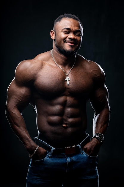 Cool and muscular black young man with strong muscles. Portrait of an athletic african american looking at camera.