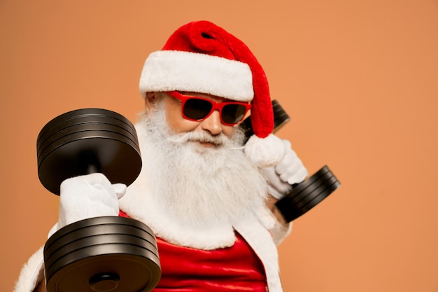 Cool Santa Claus with real beard workout with two dumbbells