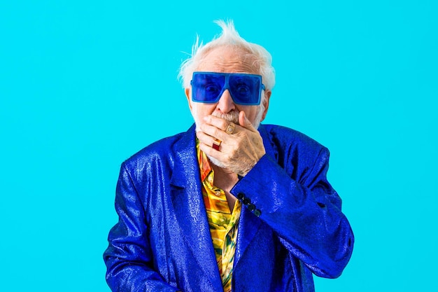 Cool senior man met modieuze kledingstijl portret op gekleurde achtergrond