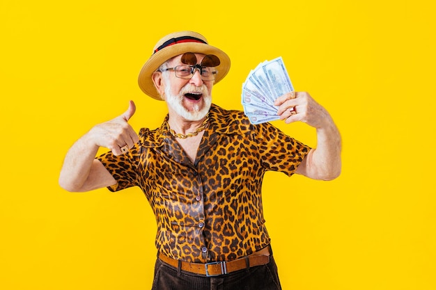 Cool senior man with fashionable clothing style portrait on colored background - funny old male pensioner with eccentric style having fun