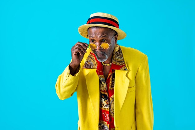 Cool senior man with fashionable clothing style portrait on colored background