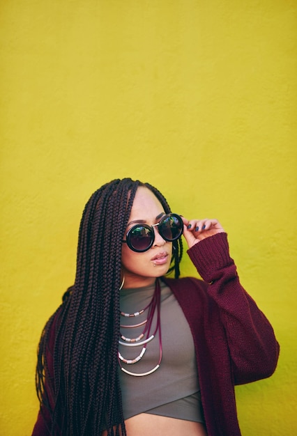 Cool and she knows it Shot of a young woman wearing sunglasses against a green background