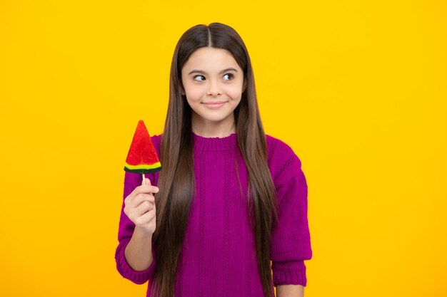 Cool tienerkind met lolly over gele geïsoleerde achtergrond Zoet jeugdleven Tienermeisje met lekker lollysuikergoed