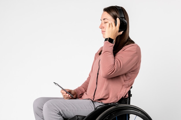 Cool woman in a wheelchair listening to music