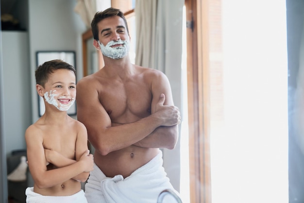 Cool yo Bijgesneden opname van een knappe jongeman die zijn zoon leert hoe hij zich moet scheren in de badkamer