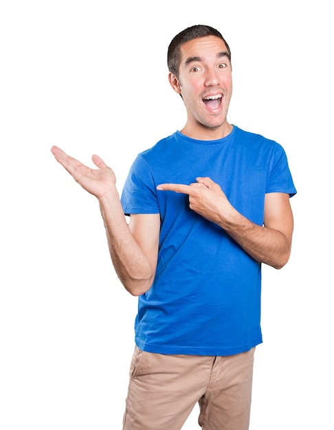 Cool young man pointing against white background