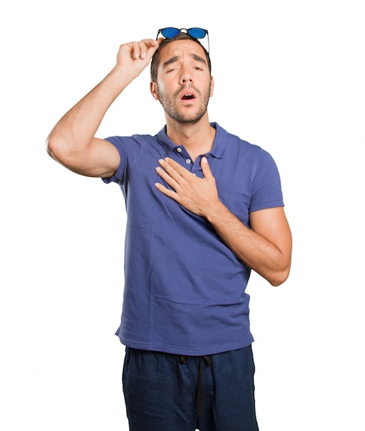 Cool young man with gesture of stress on white background