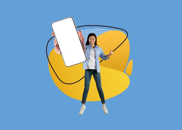 Coole app vrolijke aziatische vrouw met lege smartphone en duim opdagen
