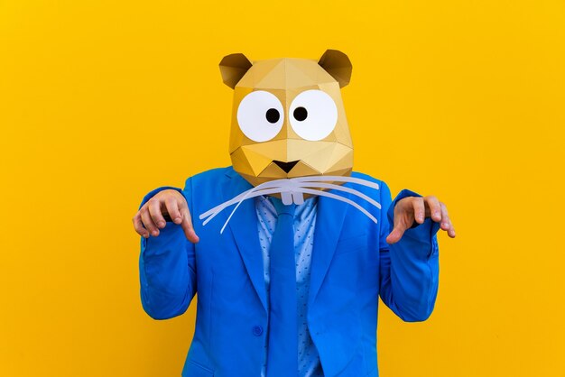 Coole man met een 3D-origamimasker met stijlvolle gekleurde kleding Creatief concept voor het adverteren van een dierenkopmasker dat grappige dingen doet op een kleurrijke achtergrond