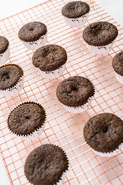 Cooling chocolate cupcakes before decorating them with icing.