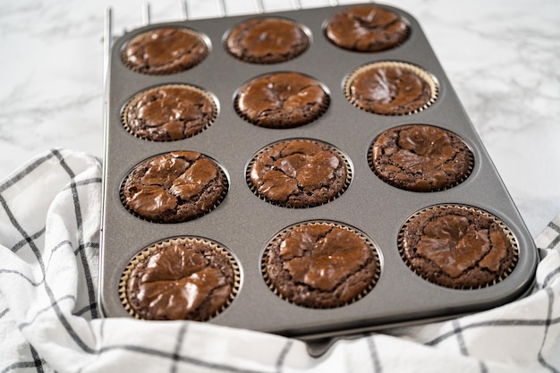 Cooling freshly baked chocolate peppermint cupcakes on a kitchen counter.