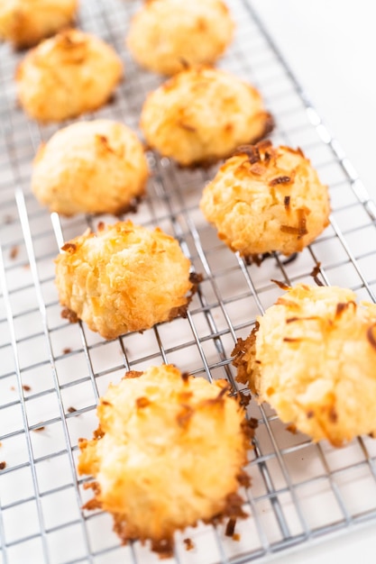 Cooling freshly baked coconut cookies on the kitchen drying rack.