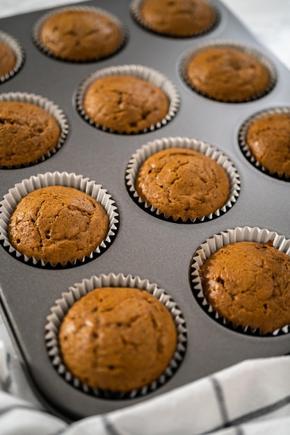 Cooling freshly baked gingerbread cupcakes on a kitchen counter