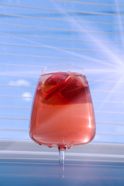 Foto sangria rinfrescante alla fragola con spumante, fragola, cubetti di ghiaccio in un bicchiere di champagne