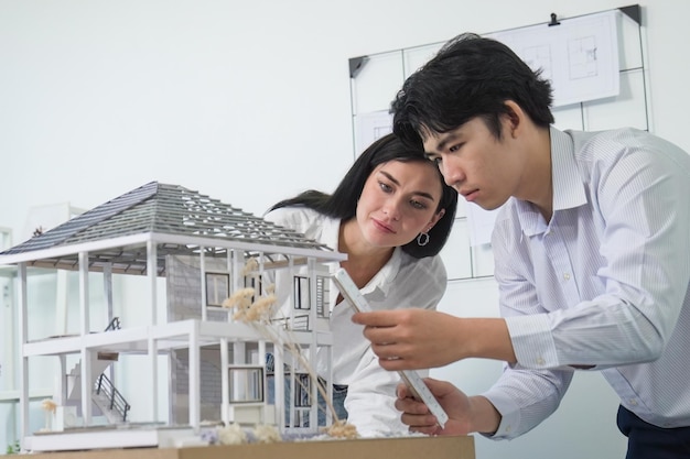 Photo cooperative engineer team working together to measure house model immaculate