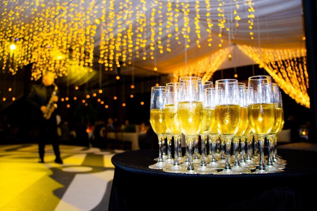 Photo copas de champana en evento con luces de fondo para brindar