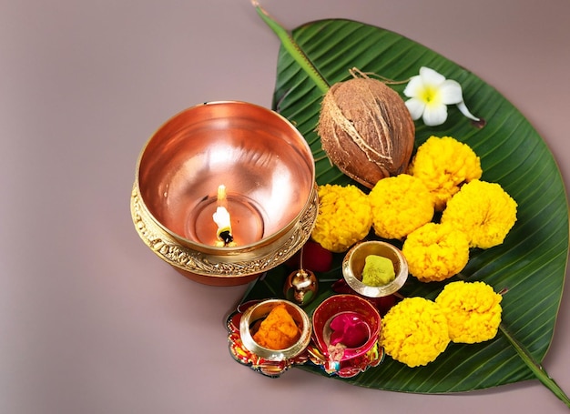 Copper and gold kalash with coconut and mango leaf with marigold flower decoration at the bottom for hindu puja for all hindu pooja occasions