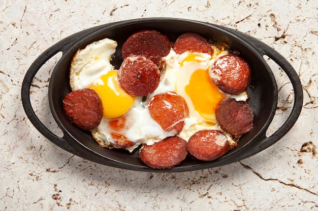 Copper pan with fried egg and sausage