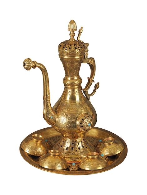 A copper teapot and cups with artistic chasing and engraving on a white background